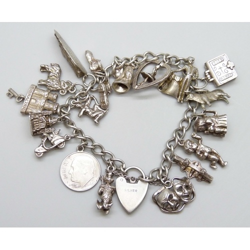 7071 - A silver charm bracelet with 18 silver and white metal charms, 59g