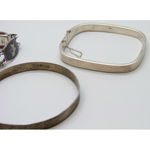 7072 - Two silver bangles and a Siam silver niello bracelet, 52g