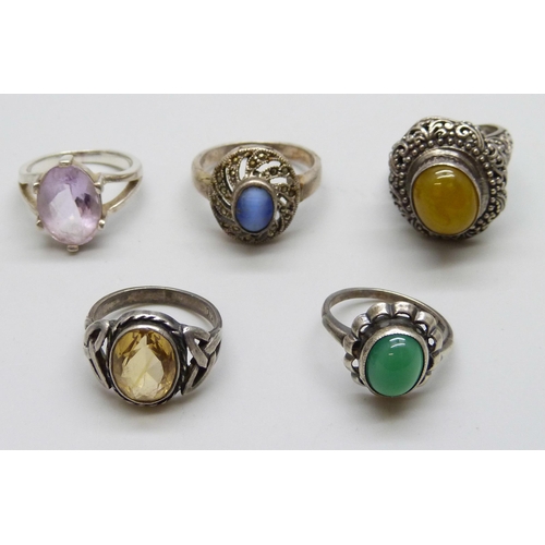 7074 - Four silver rings and a white metal purple stone ring, 26g