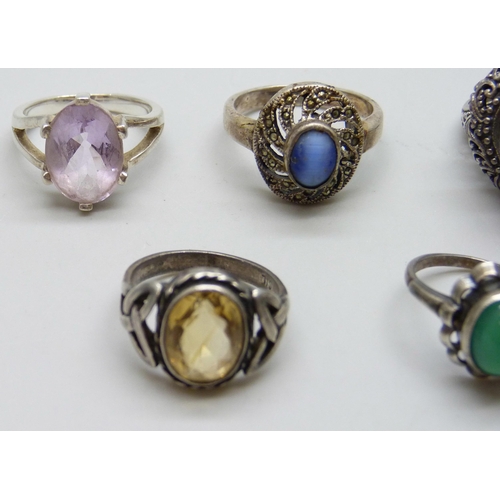 7074 - Four silver rings and a white metal purple stone ring, 26g