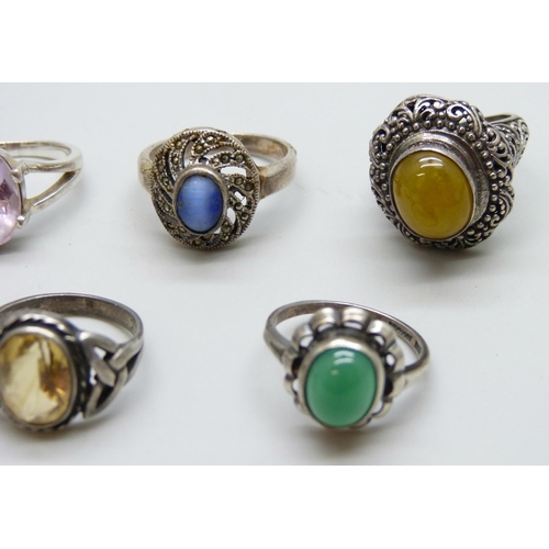 7074 - Four silver rings and a white metal purple stone ring, 26g