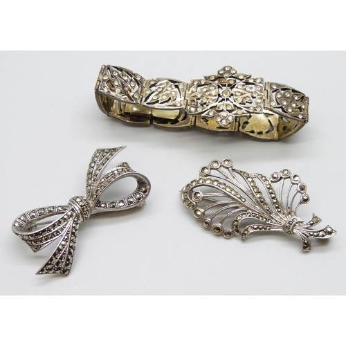 7078 - A gilt white metal bracelet set with paste stones, a silver bow brooch and a white metal brooch, 42g