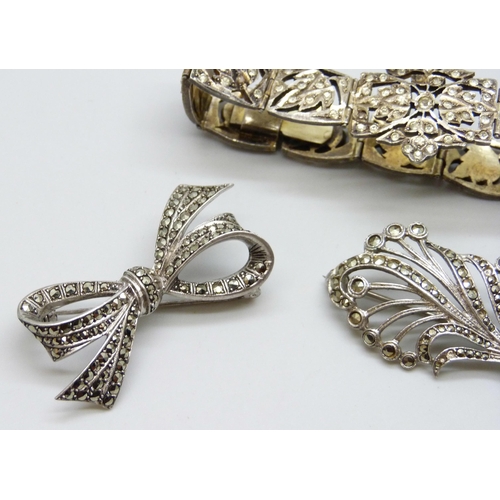 7078 - A gilt white metal bracelet set with paste stones, a silver bow brooch and a white metal brooch, 42g