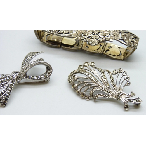 7078 - A gilt white metal bracelet set with paste stones, a silver bow brooch and a white metal brooch, 42g