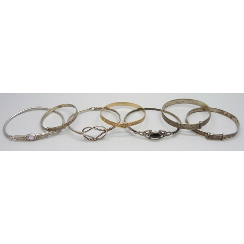 7082 - Six silver bangles and a 'gold metal core' bangle, 52g total