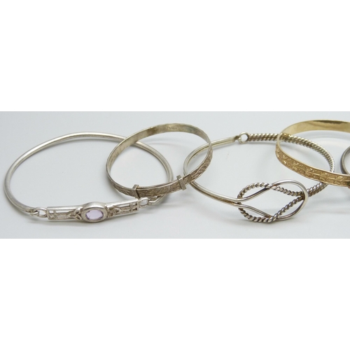 7082 - Six silver bangles and a 'gold metal core' bangle, 52g total