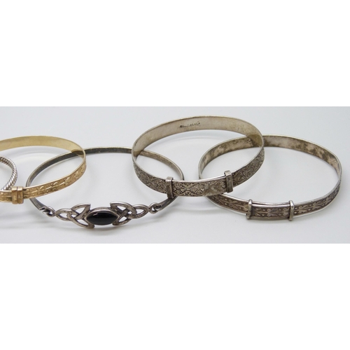 7082 - Six silver bangles and a 'gold metal core' bangle, 52g total