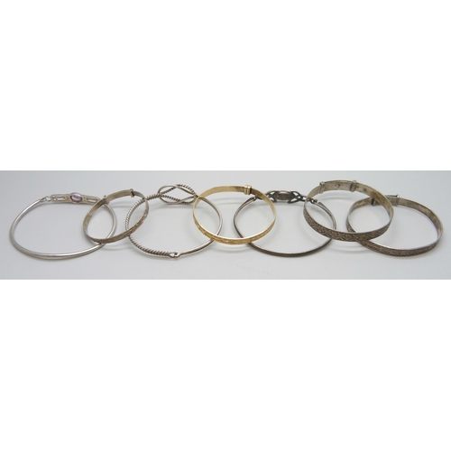 7082 - Six silver bangles and a 'gold metal core' bangle, 52g total