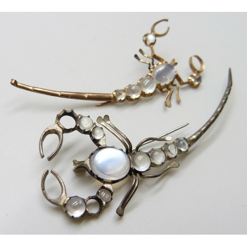 7115 - Two scorpion brooches set with moonstones, gilt example lacking hook, largest 7.2cm