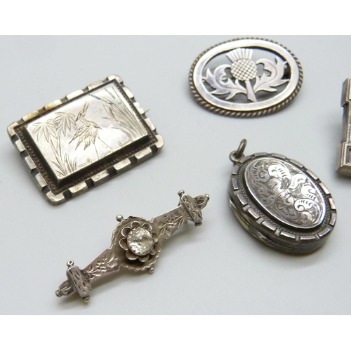 7117 - A Victorian silver locket, a Victorian silver brooch set with a stone, lacking pin, a silver thistle... 