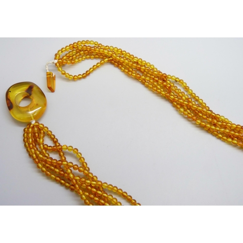 7132 - An amber coloured bead necklace, 58g