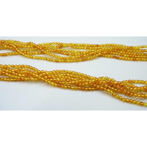 7132 - An amber coloured bead necklace, 58g