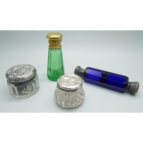 7258 - A white metal mounted double scent bottle, a green glass scent bottle, together with two silver topp... 