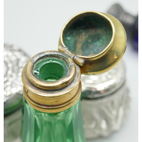 7258 - A white metal mounted double scent bottle, a green glass scent bottle, together with two silver topp... 