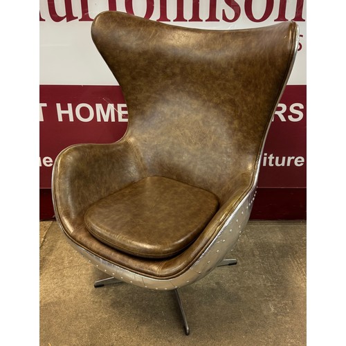 78J - An aviation style riveted chrome and brown leather revolving egg chair