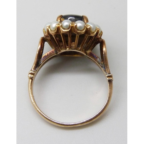 7002 - A 14k gold ring set with a brown star sapphire and pearls, 4.9g, J