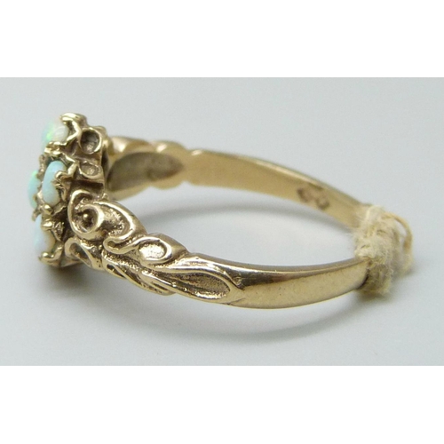 7018 - A 9ct gold ring set with seven opals, 2.6g, M