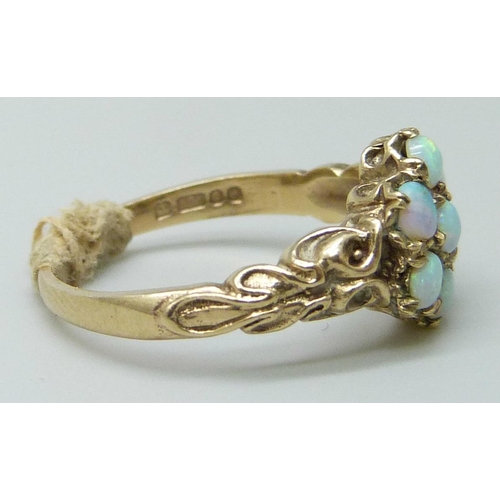 7018 - A 9ct gold ring set with seven opals, 2.6g, M