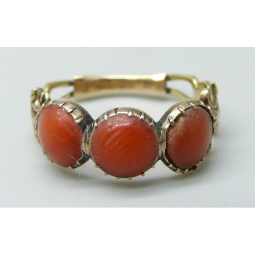 7020 - A 19th Century yellow metal and coral ring, 1.5g, J, and a pair of gilt earrings also set with coral