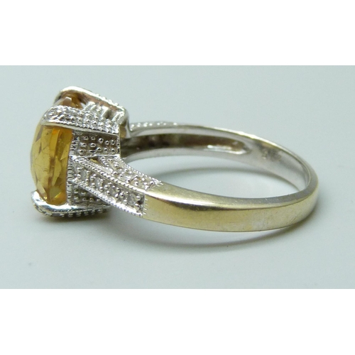 7047 - An 18ct gold ring set with a central citrine and diamond setting and shoulders, 5.5g, P