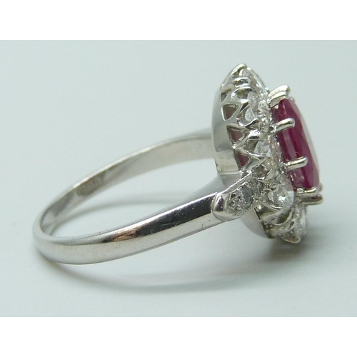 7048 - A platinum ring set with a central ruby and diamond surround and shoulders, 9mm x 6mm ruby, 6.3g, N