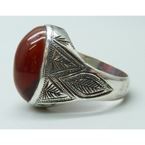 7086 - A large silver ring set with a cabochon carnelian stone, stone 2 x 1.4cm, 14.8g, V