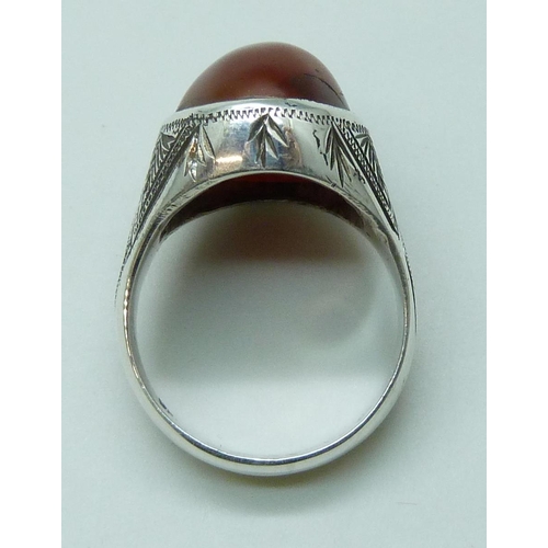 7086 - A large silver ring set with a cabochon carnelian stone, stone 2 x 1.4cm, 14.8g, V