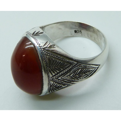 7086 - A large silver ring set with a cabochon carnelian stone, stone 2 x 1.4cm, 14.8g, V