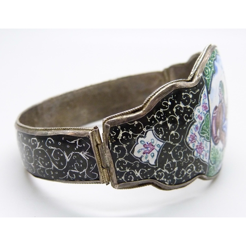 7103 - An Eastern enamelled bangle with a hand painted scene, 34g