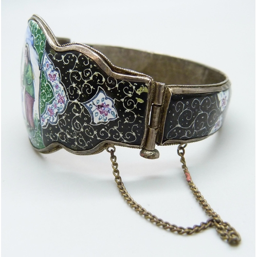 7103 - An Eastern enamelled bangle with a hand painted scene, 34g