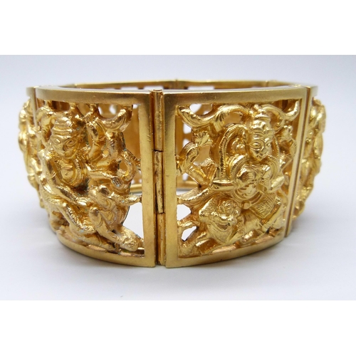 7112 - An Eastern gilt metal fretwork panel bangle, 104g,  3.5cm wide