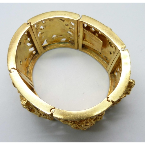 7112 - An Eastern gilt metal fretwork panel bangle, 104g,  3.5cm wide