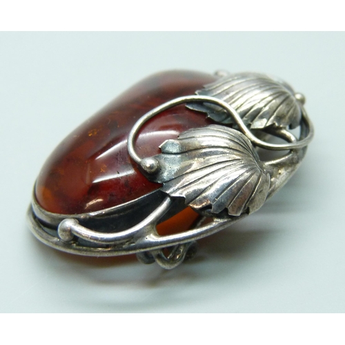 7125 - An Art Nouveau style silver and amber brooch, 12g, 4cm