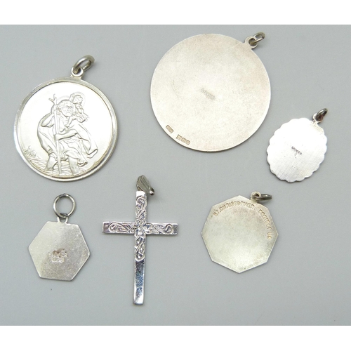 7126 - Five silver St Christopher pendants including a Georg Jensen enamelled example, and a silver cross, ... 