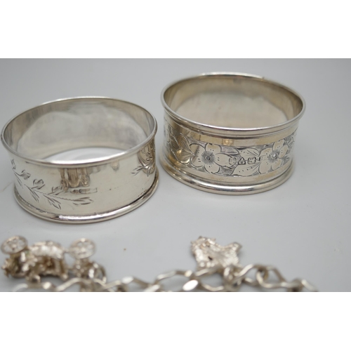 7254 - Two silver napkin rings and a silver bracelet with white metal charms, 36g total