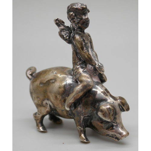 7261 - A small .800 silver model of a cherub riding a pig, 4cm, 26g