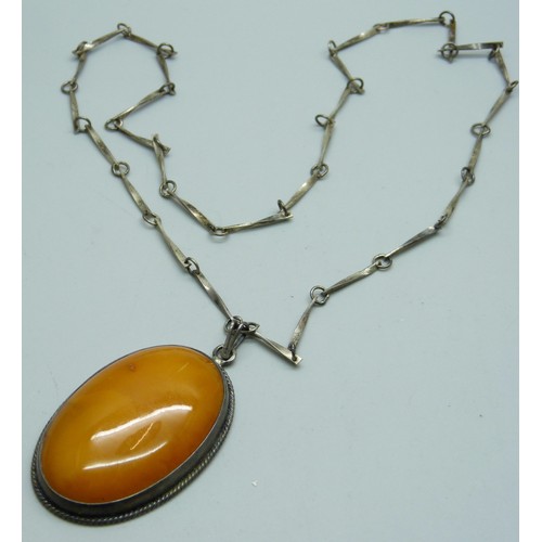 7148A - An Early 20th Century silver and butterscotch amber pendant and chain, 30g, 6cm pendant