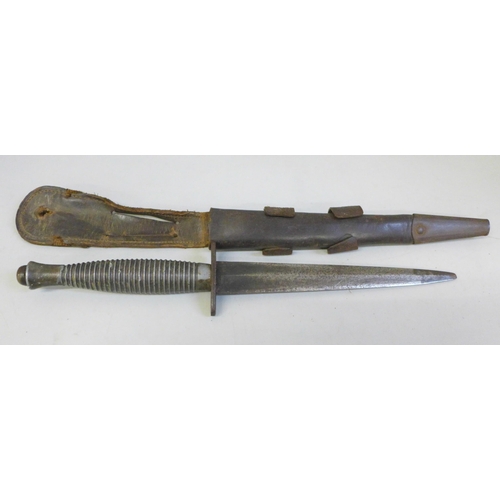 2168 - A Fairbairn-Sykes Commando fighting knife and scabbard, ring grip pattern, broad arrow over '4' on t... 