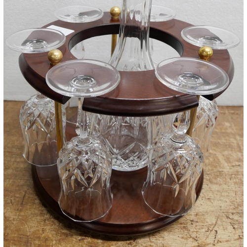 2207 - A glass decanter and six wine glasses set presented within a wood and brass circular decanter stand ... 