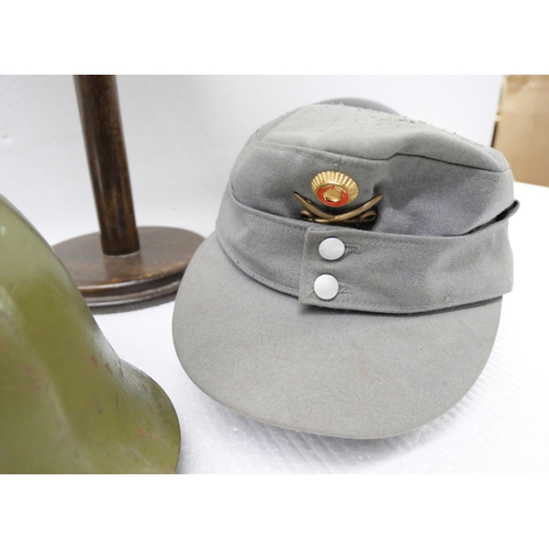 2217 - A collection of Militaria - four Military helmets and a cap