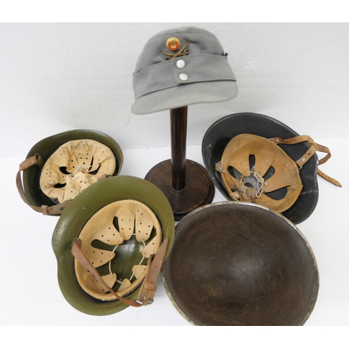 2217 - A collection of Militaria - four Military helmets and a cap