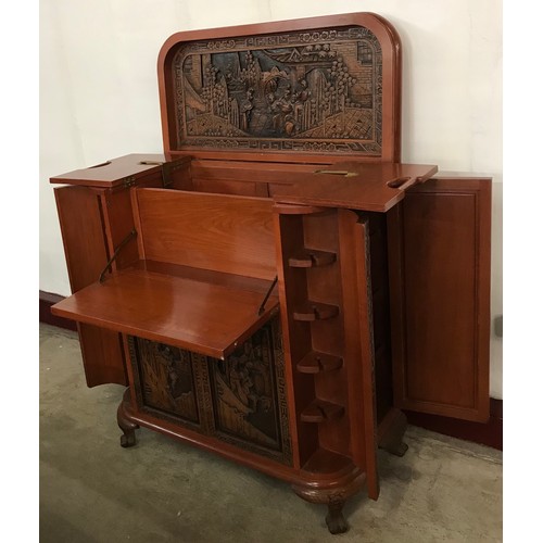 129 - A Chinese carved hardwood cocktail cabinet