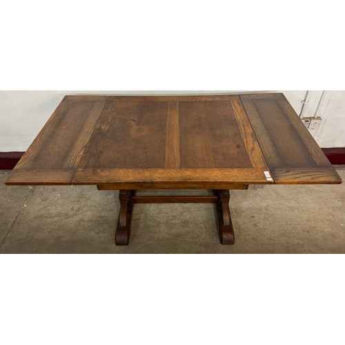 137 - An early 20th Century oak draw-leaf dining table