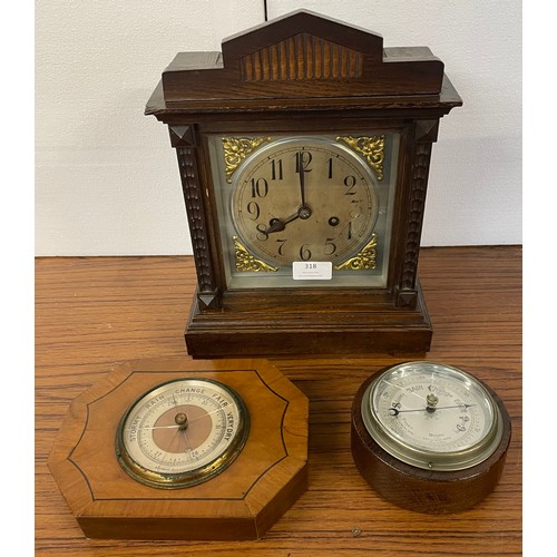 318 - An oak mantel clock and two aneroid barometers