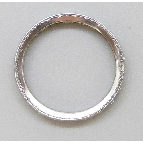 7043 - A white metal diamond set eternity ring, tests as platinum, 4.1g, N/O