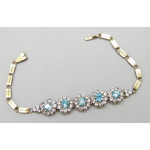 7064 - A yellow metal bracelet set with central topaz and white spinel clusters, 9.5g, 18.3cm