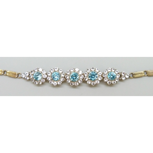 7064 - A yellow metal bracelet set with central topaz and white spinel clusters, 9.5g, 18.3cm