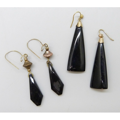 7070 - A pair of carved jet earrings with yellow metal hooks, and another pair of plastic earrings with gil... 