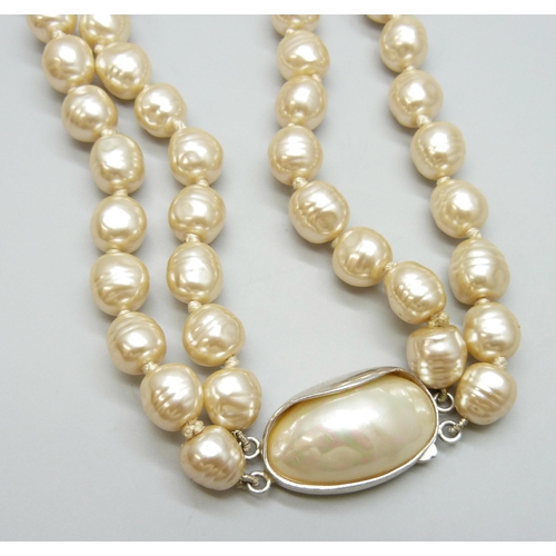 7088 - A double string of pearls set with a large silver clasp, 145g, pearls approximately 1cm