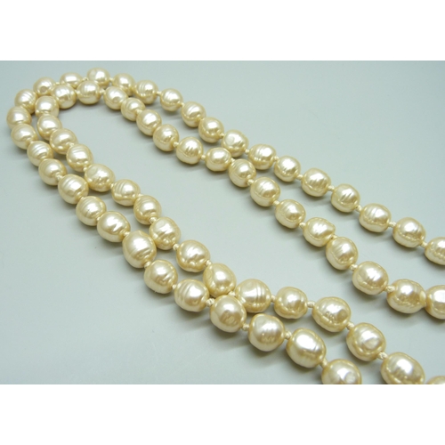 7088 - A double string of pearls set with a large silver clasp, 145g, pearls approximately 1cm